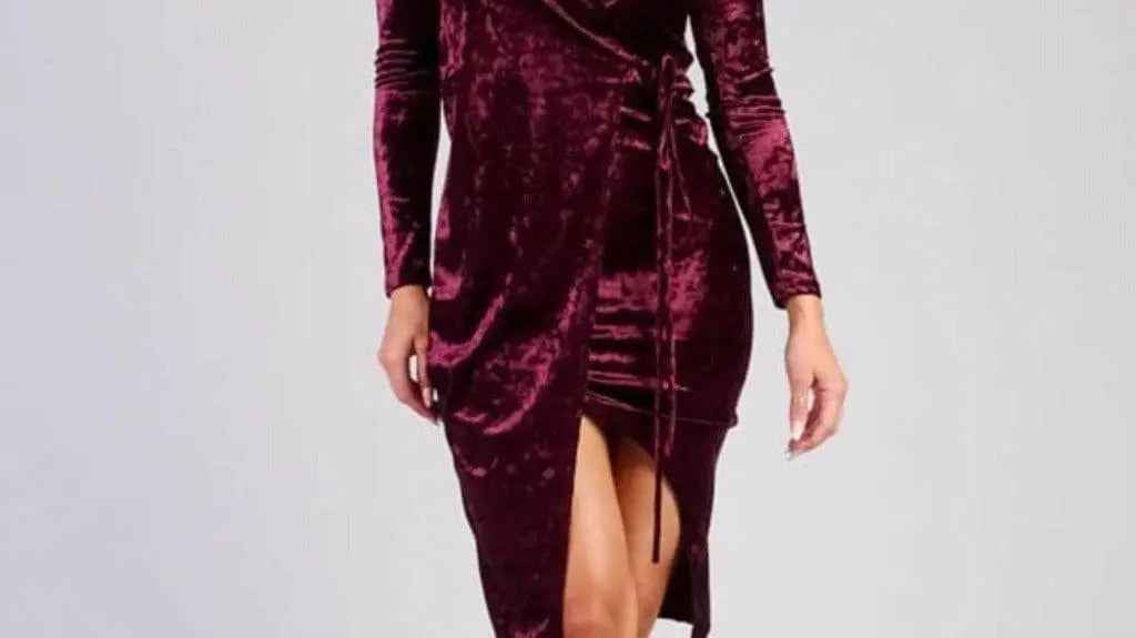 Woman wearing an elegant burgundy velvet wrap midi dress