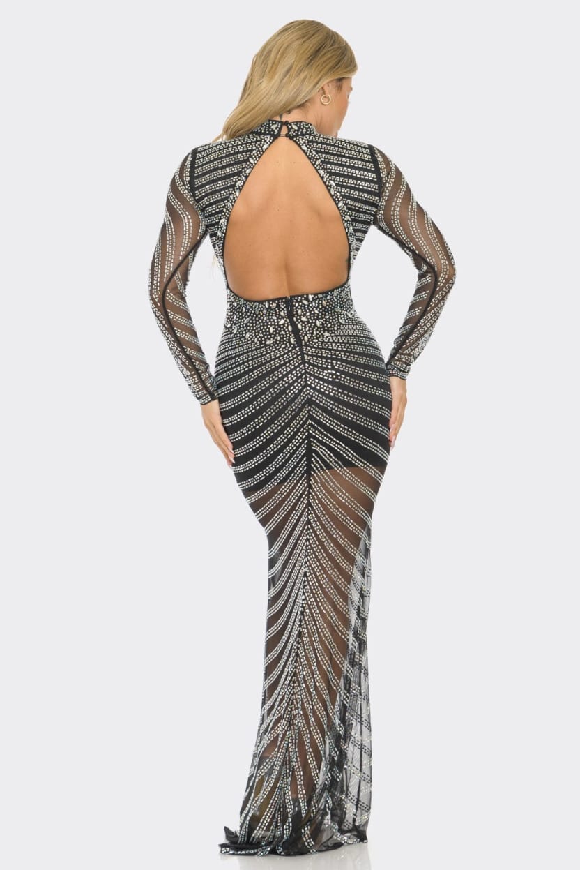A woman modeling a long-sleeve, backless maxi dress from the back, featuring a black and silver geometric beaded pattern over sheer mesh fabric, set against a light gray studio background.