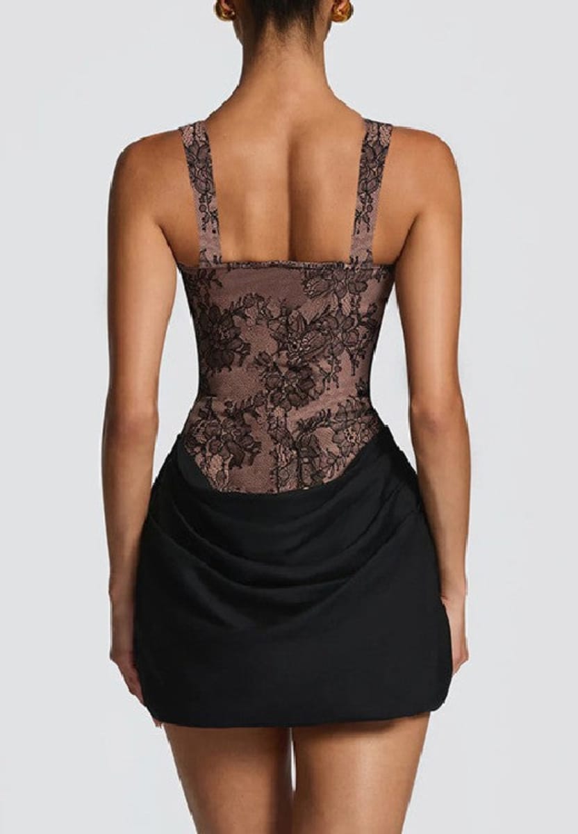 A model shown from the back wearing a black and brown floral lace mini dress with a ruched black skirt against a light gray background.