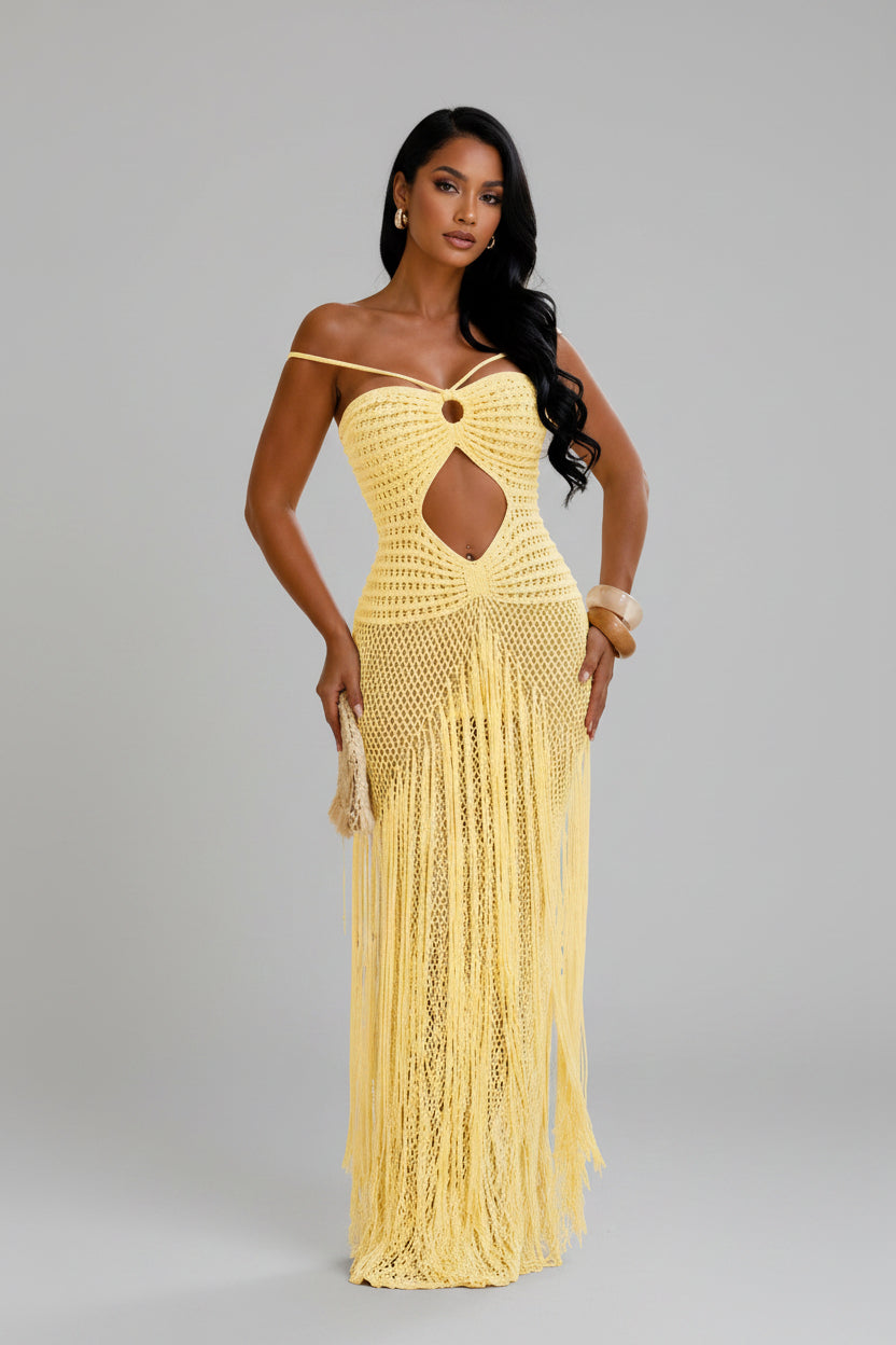 Woman wearing a yellow crochet dress with cut-out design outdoors.