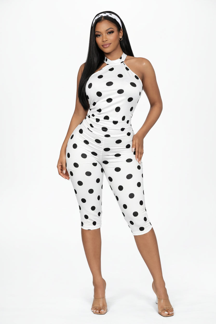 Woman wearing a white jumpsuit with black polka dots on a white background