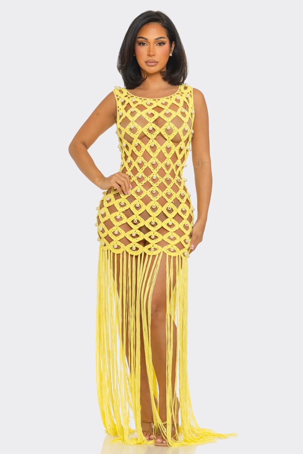 Woman wearing a yellow fringe dress on a light gray background