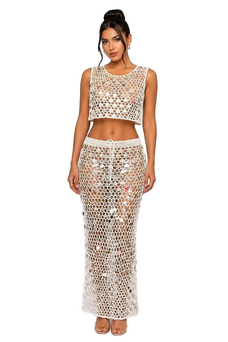 Woman wearing a white crochet top and skirt set on a white background