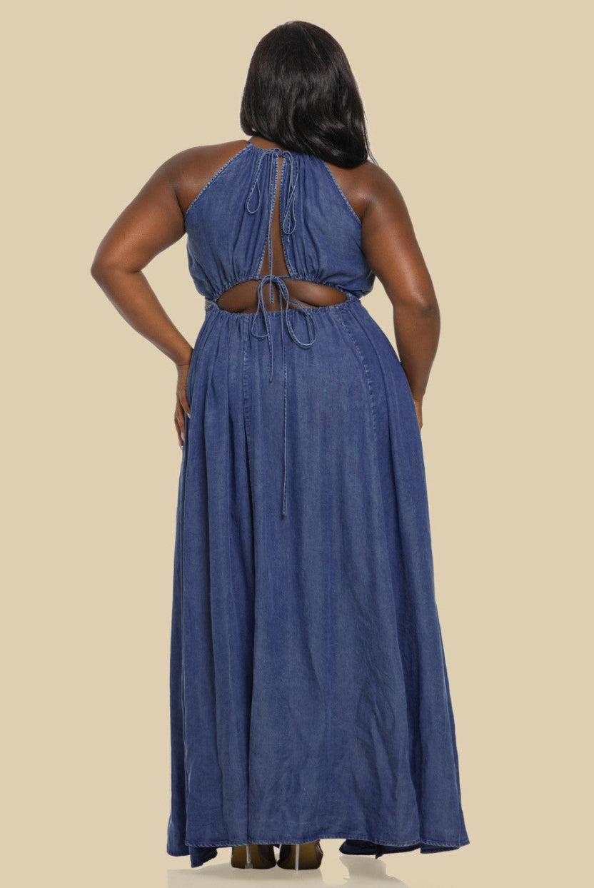 Woman wearing a blue denim dress with cut-out back on a beige background