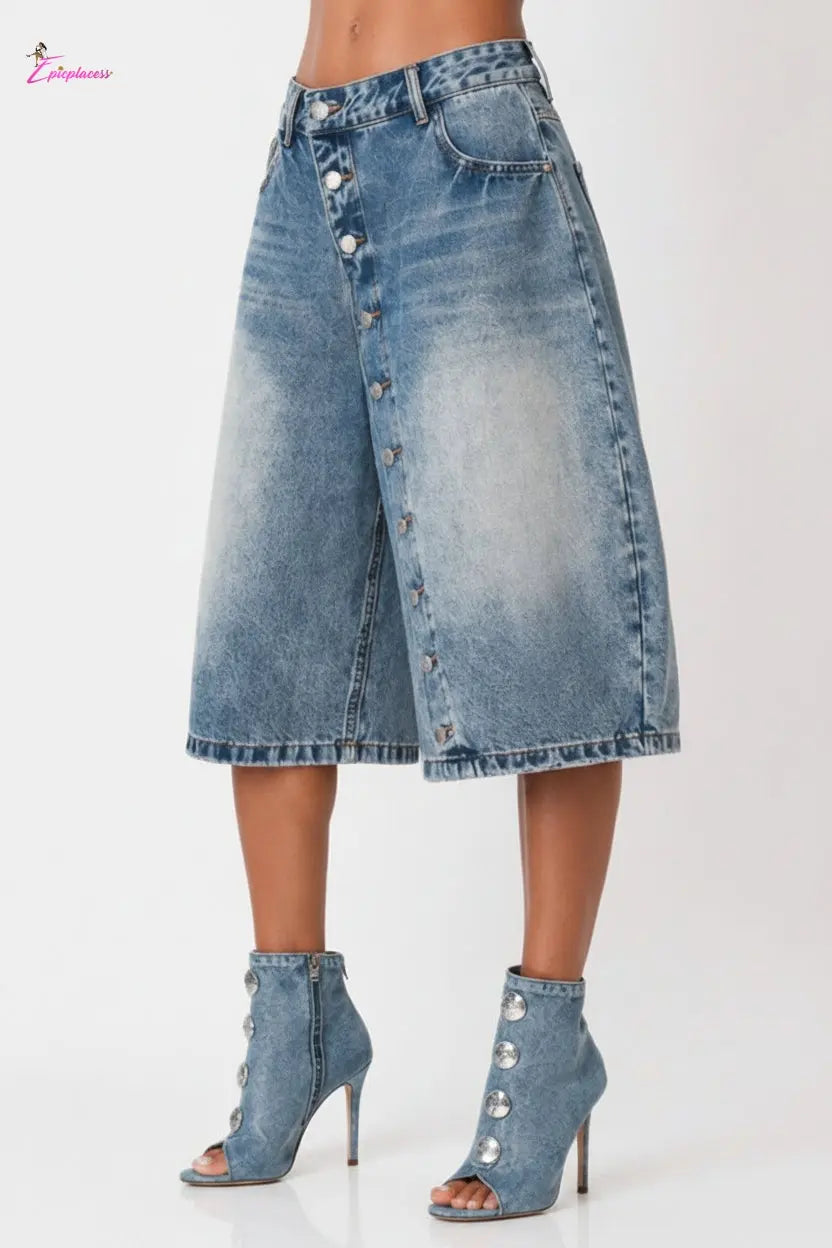 Blue denim skirt with button details worn by a person on a white background