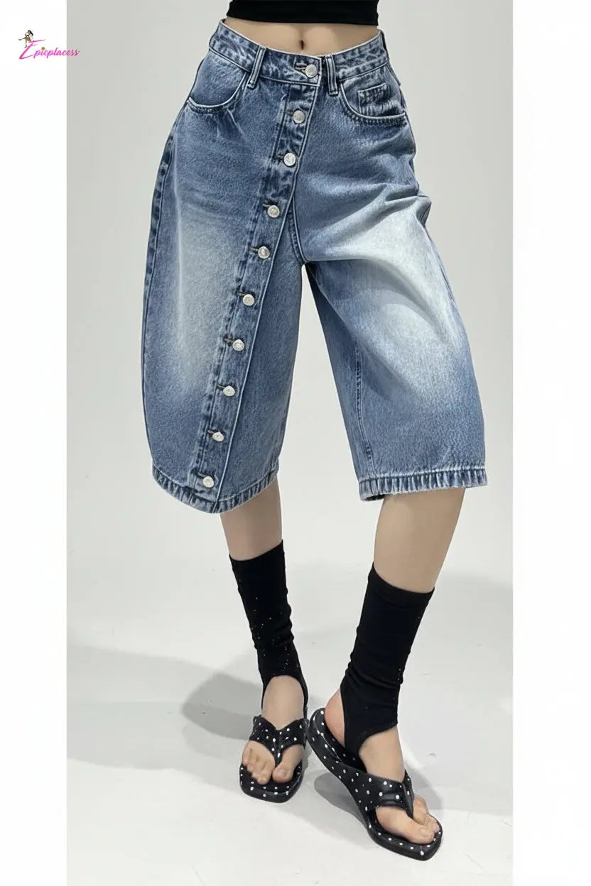 Person wearing a blue denim skirt with button details in an indoor setting.