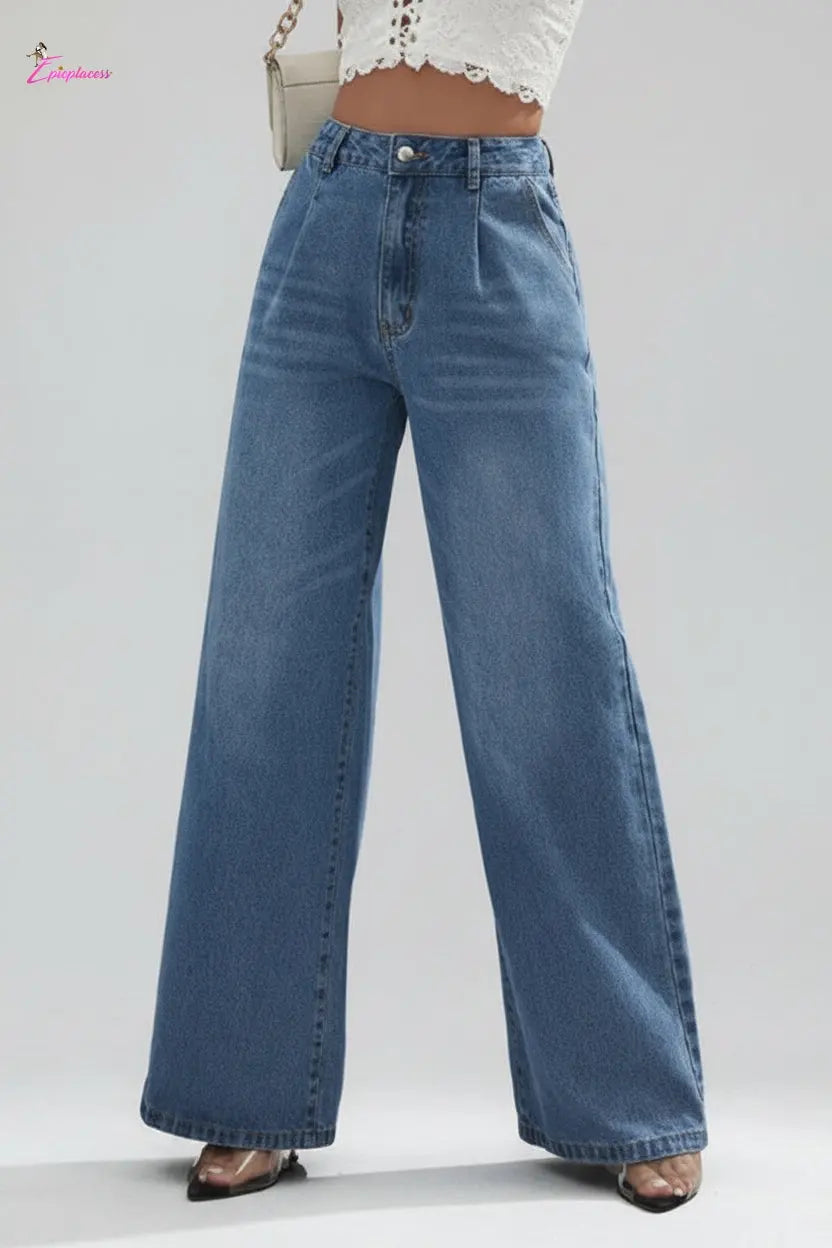 Person wearing blue wide-leg jeans on a city street.