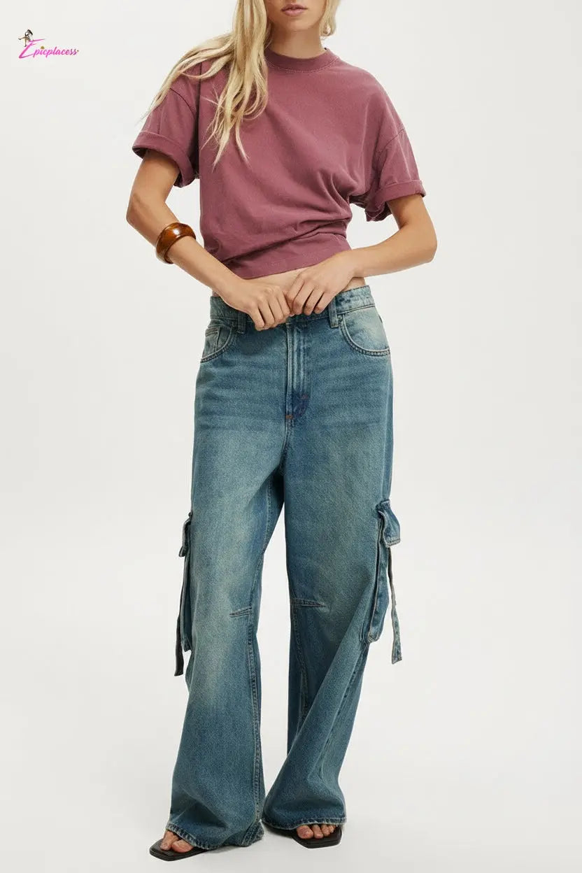 Person wearing a maroon t-shirt and blue cargo pants on a white background