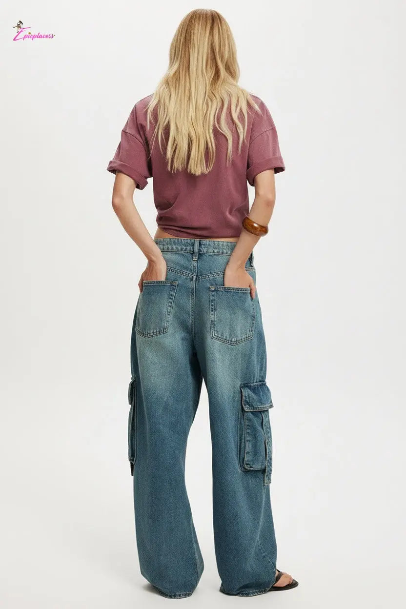 Person wearing a maroon crop top and blue cargo pants on a white background