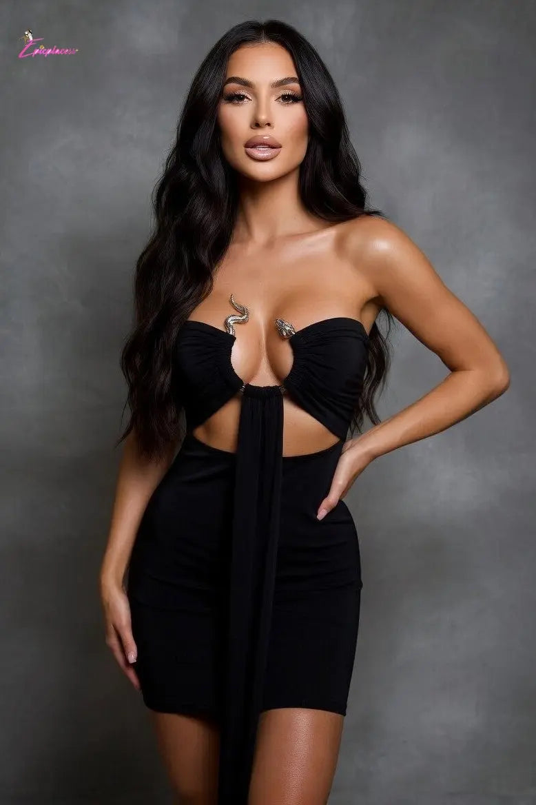 Woman wearing a black dress with cut-out design against a gray background