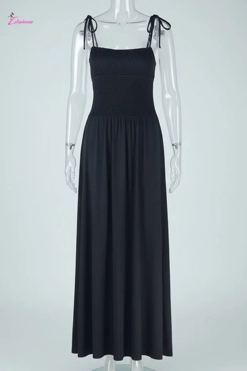 Black dress with bow straps on a mannequin against a white background