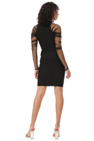 A woman shown from the back wearing a black bodycon mini dress with sheer mesh sleeves and crisscross strap detailing on the shoulders, paired with clear high-heeled sandals against a white background.