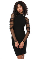 A woman modeling a black bodycon mini dress with sheer long sleeves featuring horizontal mesh cutouts, posed against a solid white background.