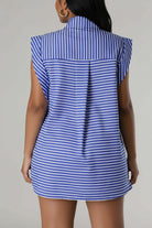 Woman wearing a blue and white striped dress against a gray background