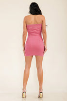 Pink strapless dress worn by a person on a beige background