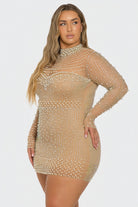 A woman modeling a sheer beige long-sleeve mini dress covered in rows of small pearl-like beads against a light gray studio background.