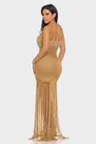 Woman wearing a gold fringe dress on a white background