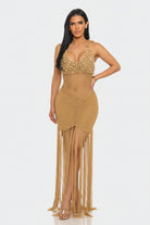 Woman wearing a gold beaded dress with fringe on a white background
