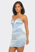 A woman modeling a strapless light blue satin mini dress with beaded embellishments on a light gray background.