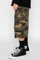 Camouflage shorts worn by a person with black high-top sneakers on a white background