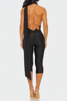 Black open-back jumpsuit worn by a model on a white background