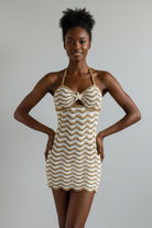 Beige and white crochet dress on a mannequin against a beige background