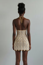 Woven dress on a mannequin against a beige background