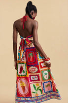 Woman wearing a colorful, patterned dress with a beige background
