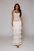Woman in a white lace dress standing on a staircase