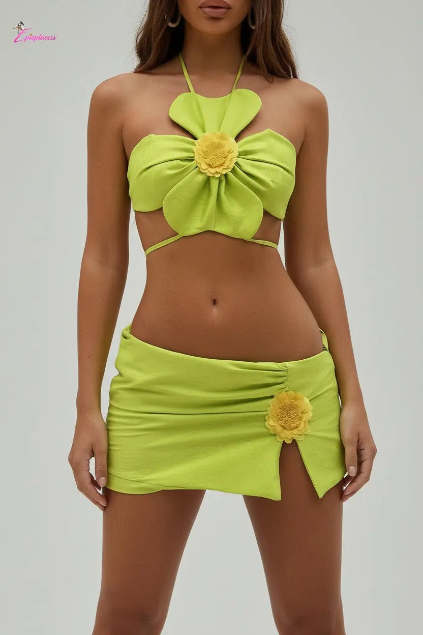 Woman wearing a bright green bikini with floral designs on a beach.