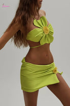 Woman in a green bikini with floral details on a beach