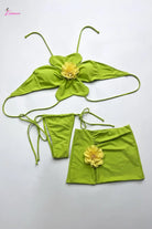 Green bikini set with yellow flower details on a white background