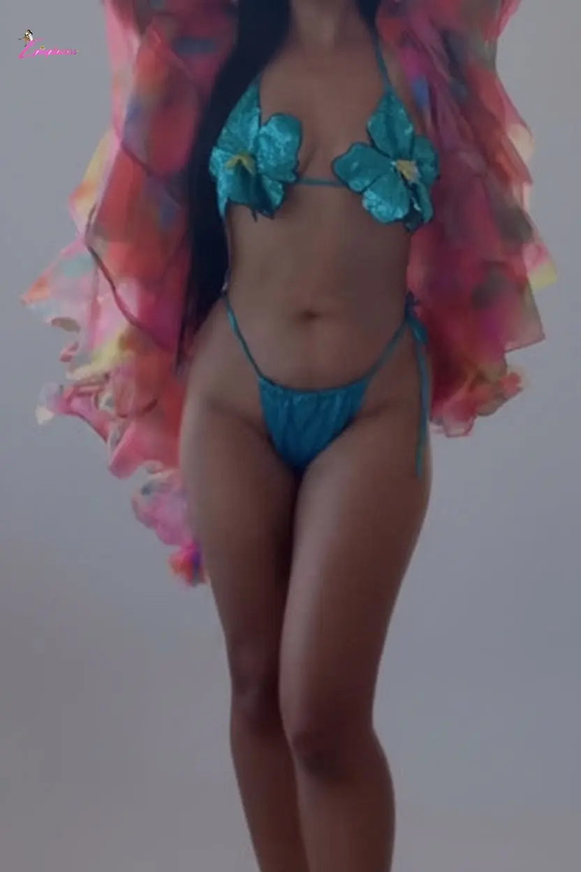 Person wearing a blue bikini with floral designs and a pink cover-up in an indoor setting.