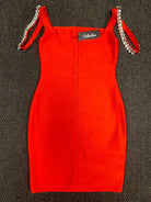 Red dress with chain straps on a textured black surface