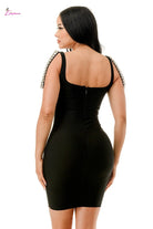 Black dress with embellished straps worn by a model on a white background
