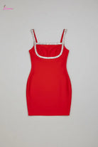 Red dress with embellished straps on a textured surface