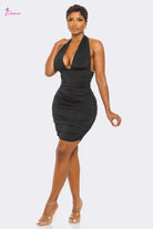 Woman wearing a black halter neck dress on a white background
