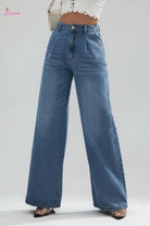 Person wearing blue wide-leg jeans on a city street.
