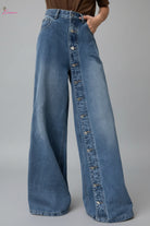 Wide-leg jeans with button details on a white background