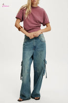 Person wearing a maroon t-shirt and blue cargo pants on a white background