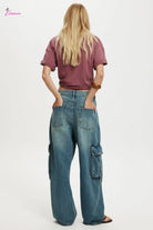 Person wearing a maroon crop top and blue cargo pants on a white background