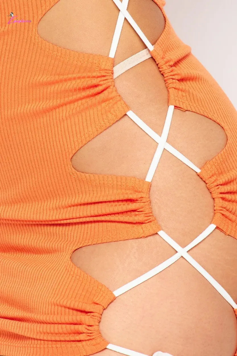 Close-up of an orange dress with cut-out design and white straps.