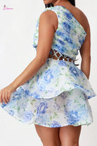 Woman wearing a floral dress with blue and green flowers on a white background