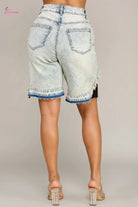 Light blue denim shorts with frayed hem on a beige background
