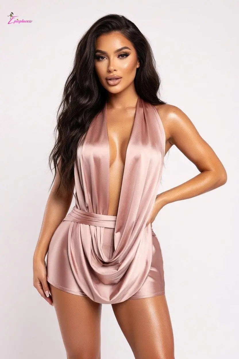 Woman wearing a pink satin romper against a white background