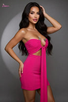 Woman wearing a pink dress with cut-out design on a gray background