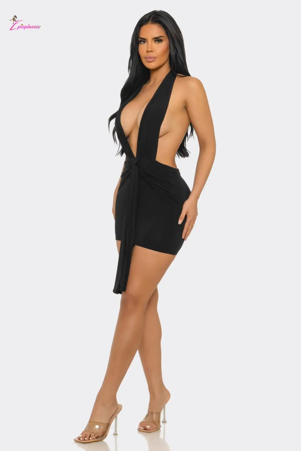 Woman wearing a black dress with a plunging neckline on a white background