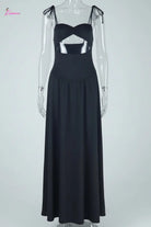 Black dress on a mannequin with sheer sleeves against a white background
