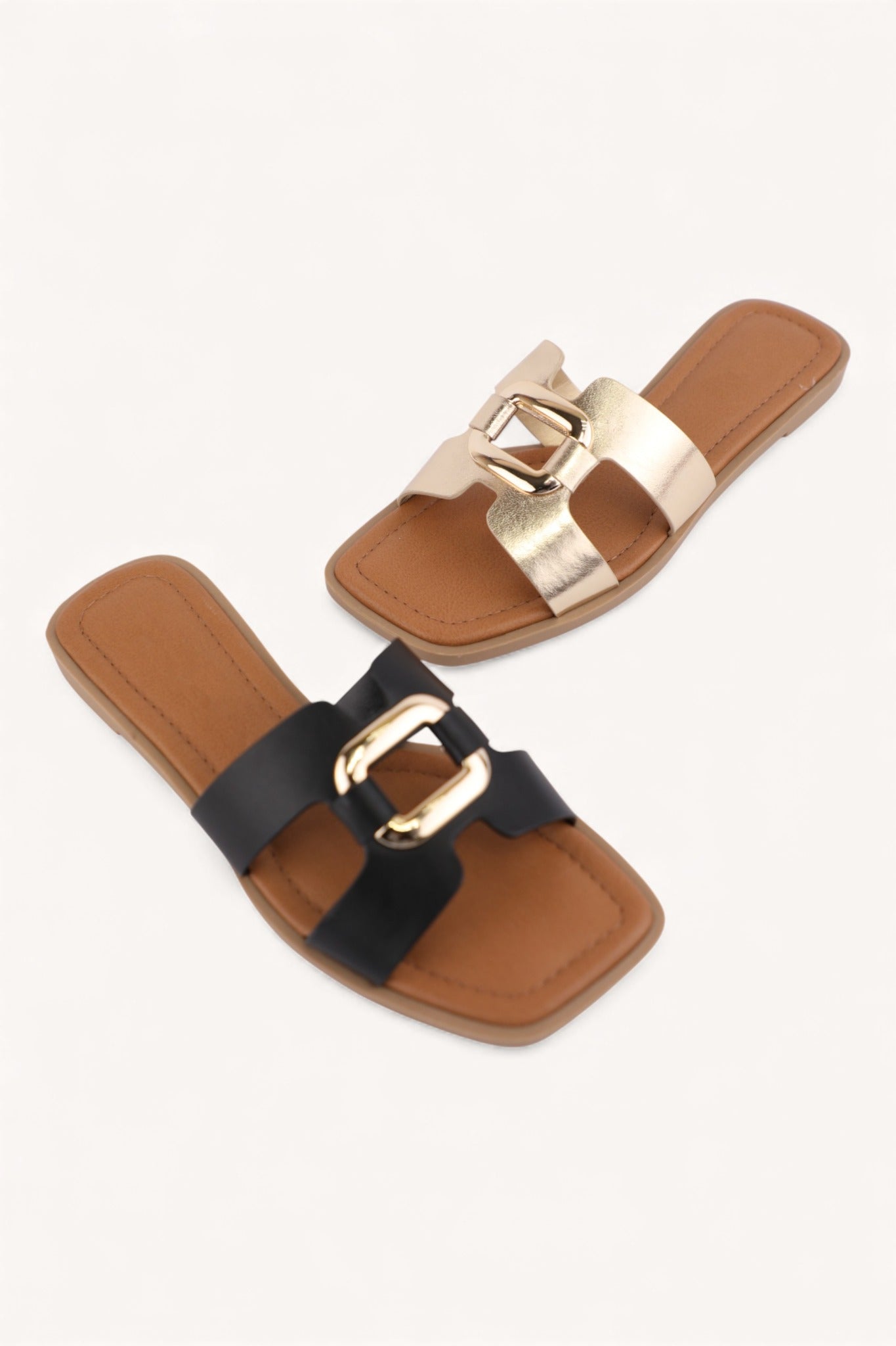 Black and gold square toe flat slide sandals with metallic link detail and tan footbed