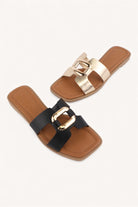 Black and gold square toe flat slide sandals with metallic link detail and tan footbed